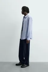 Camisa slim fit de algodón color celeste, con cuello italiano y manga larga con puños abotonados. Cierre frontal de botonadura.