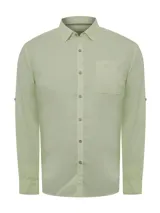 Camisa de manga larga RKF modelo Galiton, confeccionada en popelina de algodón orgánico color verde claro. Presenta cuello camisero, cierre frontal con botones de madera, bolsillo en el pecho con logo bordado y mangas ajustables. Incluye protección solar UPF 20+.