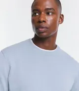 Sueter masculino de cuello redondo, color celeste, manga larga, con bajo y puños ajustados.