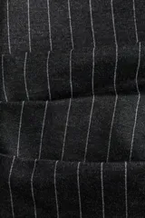 Top entallado de un hombro confeccionado en punto roma, color gris con patrón de rayas verticales finas. Presenta un escote asimétrico, pliegues decorativos en el hombro y en la cintura que generan un efecto drapeado, y un diseño sin mangas con un panel fino en el brazo opuesto.