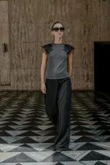 Top gris de cuello redondo y sin mangas, con detalle de flores negras de organza en los hombros.