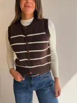 Chaleco tejido de punto con diseño de rayas horizontales en color marrón y blanco, con cierre frontal de botones y cuello redondo.