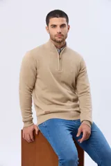 Buzo tejido liso de algodón color beige, con cuello alto, cierre frontal parcial y detalle de tirador en cuero.