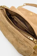 Bolso de hombro de piel color tostado con diseño acolchado y costuras geométricas. Cuenta con tres compartimentos, uno de ellos con cierre de cremallera, y solapa con cierre magnético. Incluye asa combinada de piel y cadena metálica dorada.