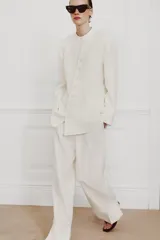 Blazer cruzado Zara Woman Collection confeccionado en hilatura de viscosa, de color blanco. Presenta cuello alto, manga larga con abertura y botones, bolsillos delanteros y cierre frontal cruzado con botones.
