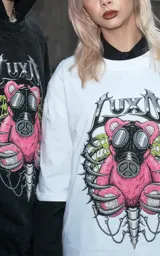 Remera blanca de corte oversize con estampa frontal de un oso de peluche rosa con máscara de gas, rodeado por una estructura ósea.