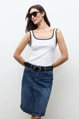 Falda midi de jean de corte recto y tiro medio, en tono azul medio con ligero efecto lavado y tajo frontal sutil.