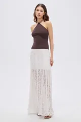 Top de viscosa color marrón, con diseño al cuerpo, escote halter y detalle de cuentas en el cuello.