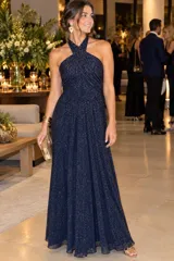 Vestido largo de tul azul marino con destellos dorados, escote halter cruzado y drapeado, con corte en la cintura y falda amplia.