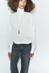 Jersey de punto extrafino con cuello subido y manga larga con sisa ancha que se estrecha hacia la muñeca.