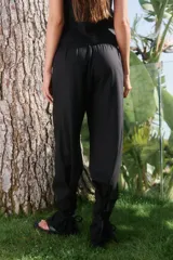 Pantalón de lino y rayón color negro, con corte holgado, cintura elástica en la parte trasera y bolsillos delanteros. Presenta lazos ajustables en la botamanga.