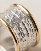 Anillo ancho de plata 925 con diseño texturizado en la banda central y bordes en lámina de oro 18k.