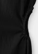 Vestido midi negro sin mangas, con cuello redondo y diseño recto con sutil frunce en los laterales de la cintura.