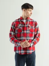 Camisa de franela a cuadros color celeste, gris y negro, de manga larga con dos bolsillos frontales con solapa abotonada.