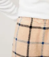 Pijama largo de dos piezas en tejido fleece. Incluye un buzo blanco de manga larga con bordado "Lazy Sunday Mood" en el frente y un pantalón largo con estampado de cuadros beige, negro y azul.