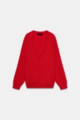 Jersey de punto liso color rojo, con escote en V profundo y mangas largas. Presenta terminaciones en rib en el cuello, puños y ruedo.