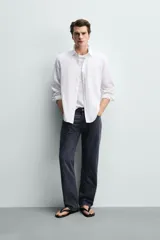 Camisa regular fit de manga larga con diseño a rayas verticales celestes y blancas. Cuenta con cuello abotonado, bolsillo de parche en el pecho y cierre frontal con botones.