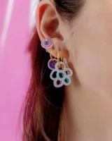 Par de aros colgantes con forma de flor, con pétalos de acrílico de colores translúcidos (naranja, verde azulado, fucsia, lila y celeste) y argollas de metal plateado.