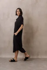 Vestido midi camisero de corte oversize color blanco, con cierre frontal de botones, mangas cortas con vuelta y ruedo redondeado.