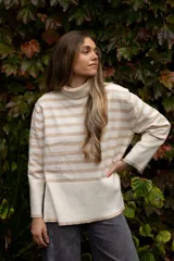 Poleron de punto con diseño a rayas horizontales en color beige y negro, cuello alto tipo tortuga, mangas largas con puños anchos y aberturas laterales en el ruedo.