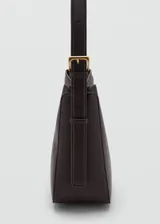 Bolso de hombro de poliuretano texturizado en color marrón oscuro, con asa ajustable, cierre de botón a presión con detalle metálico dorado y bolsillo interior con cremallera.