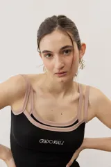 Musculosa de tejido rib color beige con detalles en marrón oscuro en el escote y doble tirante fino. Presenta un pequeño texto estampado en el pecho.