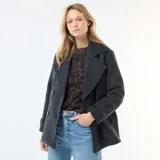 Abrigo corto de paño en color azul marino, con diseño de doble botonadura, solapas anchas y mangas largas con detalle de botón en los puños.