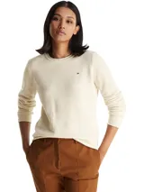 Sweater de lana de corte regular con cuello redondo y mangas largas. Presenta un diseño minimalista en color beige con el logo de la marca bordado en el pecho.