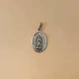 Dije de medalla ovalada con la imagen de la Virgen de Guadalupe en relieve, fabricado en plata 925 con acabado envejecido.