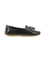 Mocasín de mujer en cuero con textura de cocodrilo, color negro, con detalle de flecos y herraje metálico en el empeine. Cuenta con suela de goma color caramelo.