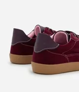 Championes estilo chutera color bordó, con recortes pespunteados, cordones con detalles contrastantes y suela de goma color caramelo.