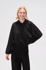 Canguro negro con capucha y mangas largas abullonadas.