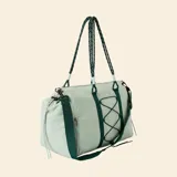Bolsa de deporte color verde claro, con correas de hombro tipo cuerda, correa ajustable extraíble y sistema de cordones elásticos en el frente para sujeción.