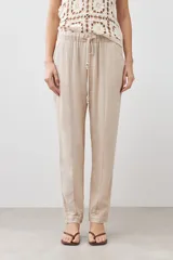 Pantalón de pijama de lino color beige melange, con cintura elástica ajustable con cordón y pespuntes en contraste.