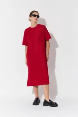 Vestido largo de manga corta con diseño oversize y cuello redondo. Presenta un corte recto y holgado con una textura sutil en la tela.