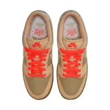 Championes Nike SB Dunk Low Pro Som Tum en tonos beige y tostado, con paneles de lona y gamuza texturizada, cordones rojos y detalles plateados en el talón.