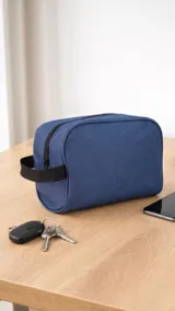 Neceser de tela canvas color azul, con cierre superior y asa lateral de mano.