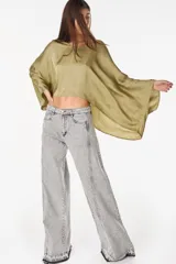 Blusa de algodón azul marino con escote en V, mangas murciélago amplias y diseño corto de corte asimétrico.