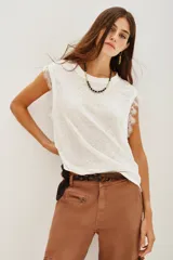 Musculosa blanca de lino con cuello redondo y detalle de encaje en las mangas.