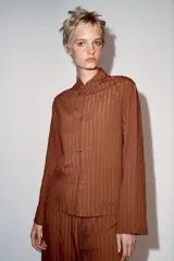 Camisa de viscosa de la colección ZW de Zara, con diseño de rayas verticales, cuello mao y cierre frontal con alamares. Tiene mangas largas y bolsillos frontales de parche.