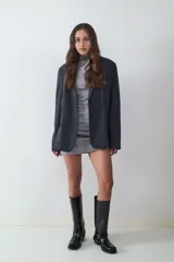Blazer negro de corte recto y diseño oversize, con cuello de solapa, cierre frontal de dos botones y bolsillos con solapa en los laterales. Interior forrado.