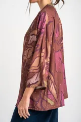 Kimono de viscosa con estampado abstracto en tonos marrones, violetas y verdes, con detalles de hilos dorados y mangas tres cuartos.
