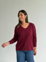 Sweater de punto en color bordó, con escote en V, mangas largas y diseño de corte recto con dobladillo ligeramente más largo en la parte posterior.