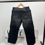 Pantalón jean cargo negro con bolsillos laterales y corte recto.