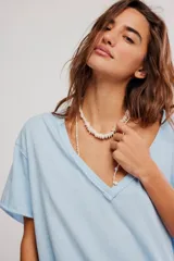 Remera de algodón celeste, de corte oversize con escote en V amplio y mangas cortas caídas.