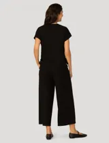 Conjunto de dos piezas compuesto por una remera de manga corta con cuello redondo y frunces laterales ajustables, y un pantalón de corte ancho con cintura elástica y bolsillos laterales.