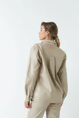 Sobrecamisa negra de efecto cuero con bolsillos frontales y botones a tono.