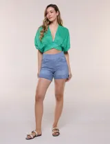Short de denim blanco tiro alto, estilo pull-on con cintura elástica ancha, bolsillos delanteros y traseros, y dobladillo en las piernas.