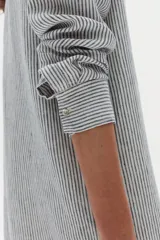 Vestido largo camisero de lino a rayas celestes y blancas, con cuello camisero, mangas largas, bolsillo aplicado en el pecho y cierre frontal con botones.