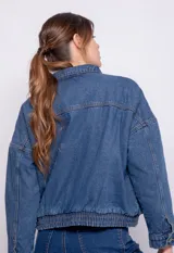 Campera de jean azul con fit holgado, bolsillos frontales grandes, elástico en la cintura y forro interior de corderito.